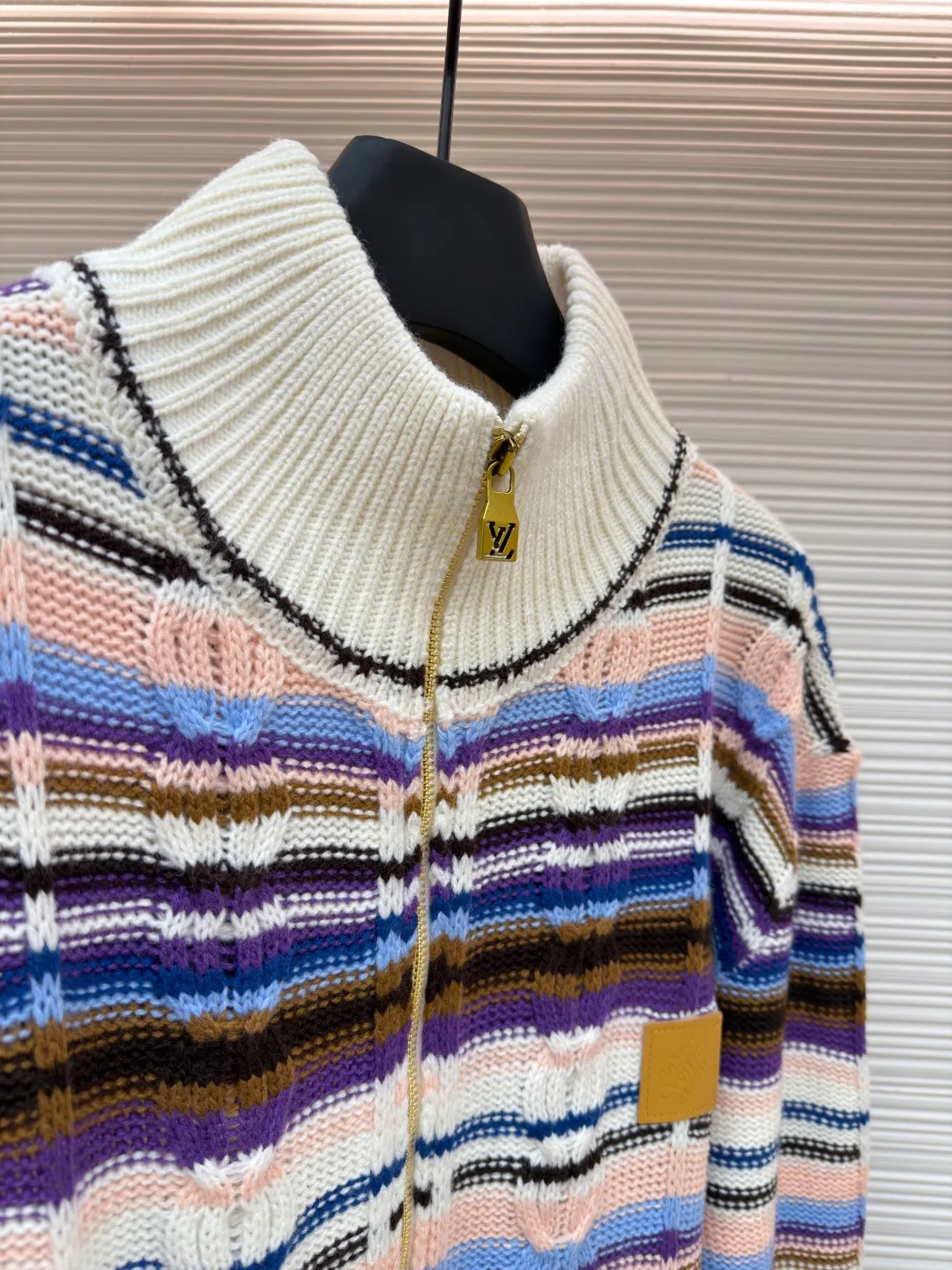 LOUIS VUITTON letter badge color block cable zipper knitted jacket ●Original version: purchased and developed by 21570 ●Item number: 1682322-C15 ●Fabric: wool blended fabric ●Technology: knitting ●Color: pattern ●Version: fitted version ●Weight: about 710 grams ●Size: S-M-L-XL ●Description: This Louis Vuitton color-blocked striped knitted cardigan is made of merino wool and cashmere blended yarn and is woven on a 12-needle coarse-gauge computerized flat knitting machine. The body is interlaced with cable knitting and plain knitting. The stripes are directly knitted with colored yarns instead of post-printing and dyeing. The ratio of colored yarns for each stripe is accurately calculated, making the color transition natural and not easy to fade. The placket is equipped with a customized brass zipper, and the zipper teeth are polished and gold-plated, which is both smooth and durable. The leather label on the left chest is fixed with first-layer calfskin through heat embossing process, and the edges are hand-polished without burrs. The neckline is designed with a high-elastic ribbed stand-up collar, which is not easily deformed after being shaped at high temperatures. The ribbed edges on the cuffs and hem are woven with double-strand yarn, which is more elastic. The shoulders are seamlessly woven with raglan sleeves to reduce the feeling of seams rubbing against the skin. The overall loose fit is combined with three-dimensional tailoring, which not only retains the soft texture of knitting, but also creates a crisp silhouette. Each piece is hand-ironed and quality-checked by brand craftsmen. The overall wiring is straight and delicate, the fabric is comfortable and soft, and the color is consistent without color difference. It can be matched with the same style to create a fashionable look and control various occasions. Customized accessories, complete with three standards, same style for men and women!